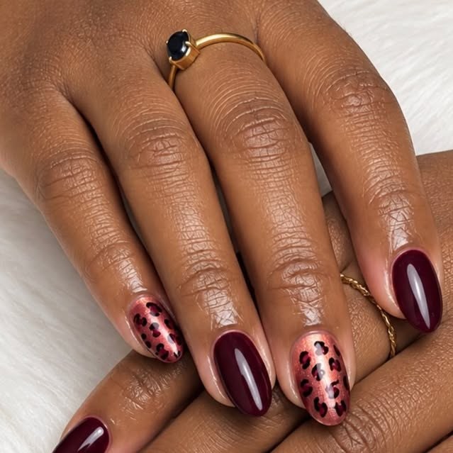 Burgundy BIAB with leopard-print accent nails on white faux fur